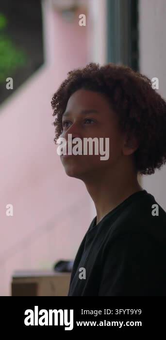 portrait of a pensive Hispanic boy of African descent with curly hair ...