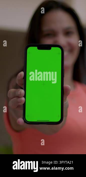 A woman holds a smartphone in vertical orientation directly toward the ...