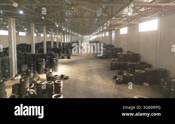 Moving view down a tire warehouse aisle toward a large metal door with ...