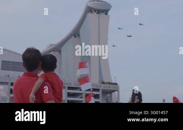 Fly Imag Helicopters fly past Marina Bay Sands while adults and children watch ...