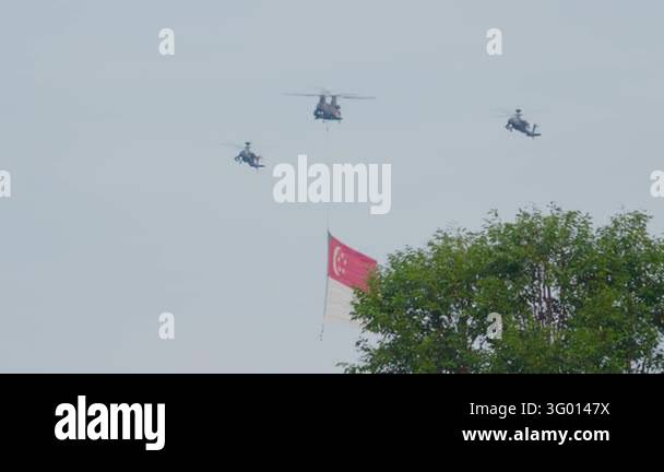 Fly Imag Three helicopters fly in formation with a large Singapore flag ...