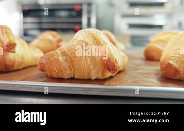 Alternative view of fresh butter croissants on a baking paper sheet ...