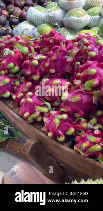 Close-up view of dragon fruit heaped in rustic wooden crate with ...