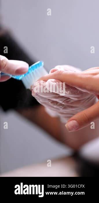 Macro close-up of nail technician brushing nail dust from client ...