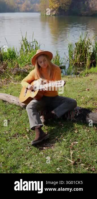 Instrument Land Portrait of smiling caucasian artist plays wooden acoustic guitar in ...