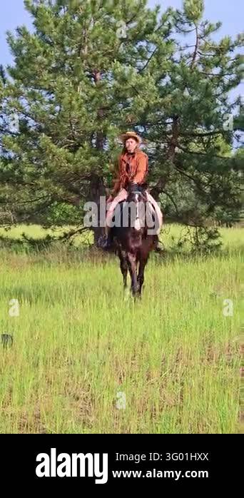 White woman in cowboy hat and fringe leather jacket riding a brown ...