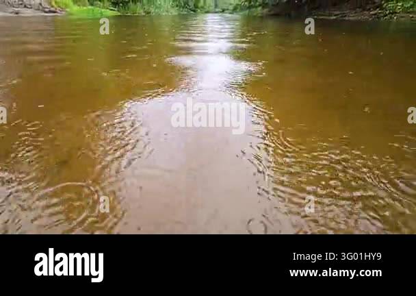 Scenic landscape of a wide river during rain looking down the flow with ...