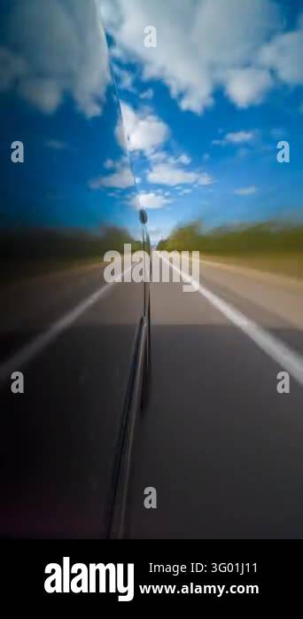 License Stree Racing Low-angle vertical timelapse beside a dark car captures road blur ...
