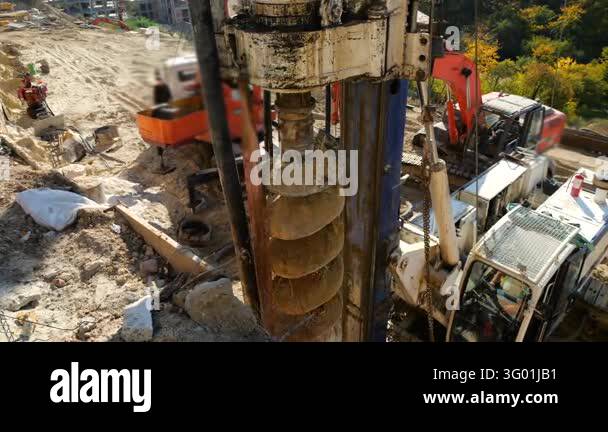 A drilling rig operates at a construction site to install bored piles ...