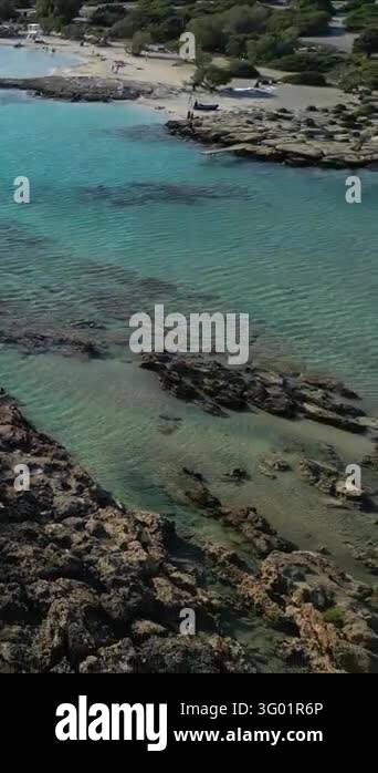 Vertical aerial view of clear turquoise sea water with rocky seabed and ...