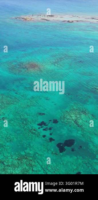 Vertical aerial top down view of turquoise sea water splashing over ...