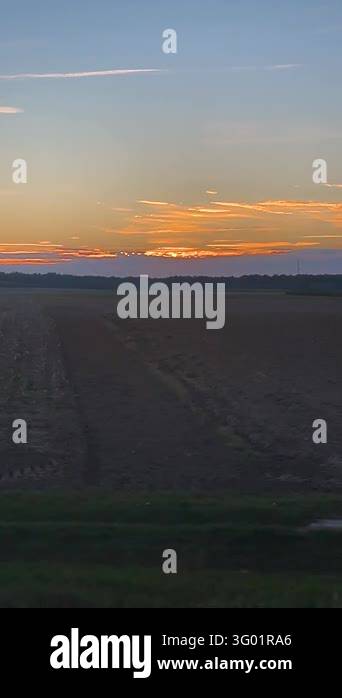 Windowed View Scenic train window view of a rural landscape at golden sunset as ...
