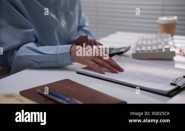 Business professional reviewing printed accounting paperwork beside a ...