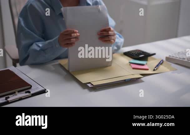 Office worker reviewing organized financial paperwork marked with ...