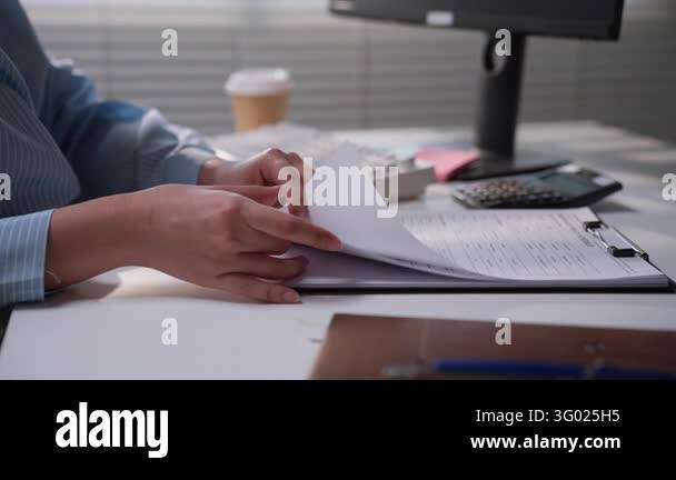 Office professional reviewing printed financial reports beside a ...