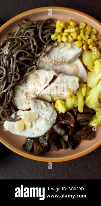 A bowl featuring slices of boiled chicken fillet, buckwheat noodles ...