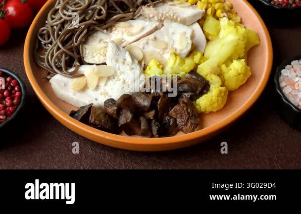 A bowl featuring slices of boiled chicken fillet, buckwheat noodles ...