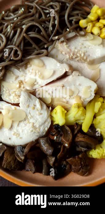 A bowl featuring slices of boiled chicken fillet, buckwheat noodles ...