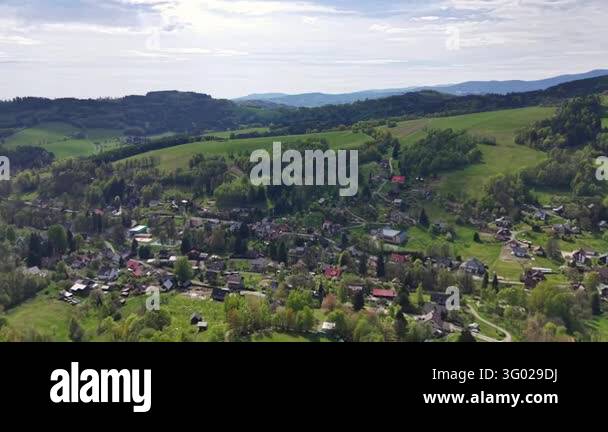 Smlll Image Aerial perspective over small village in verdant valley, with houses ...