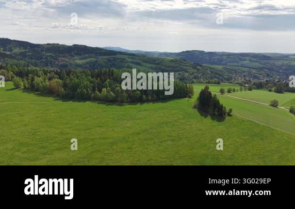 Smlll Image Elevated perspective shows winding roads through green fields, wooded ...