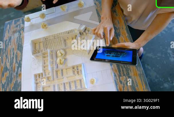 Right design lead tapping tablet, aligning 3D render with model, green ...