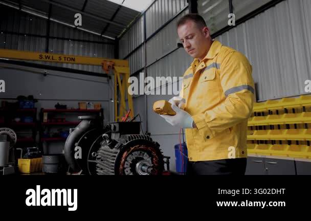 Professional Male Engineer Inspecting DC Motor in Industrial Workshop ...