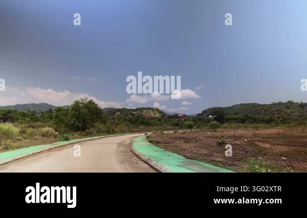 Scenic driving view along an asphalt road passing through rural ...