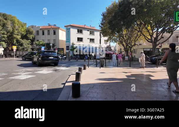 France Tree Antibes, France - September 15, 2026 - Pedestrians cross a sunny urban ...
