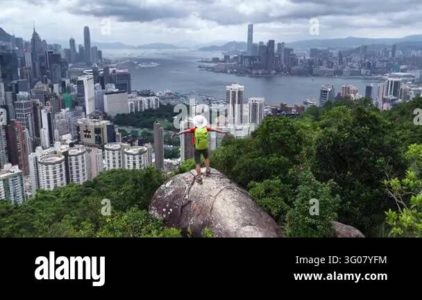 Aerial view of a person standing on a rock with arms outstretched ...