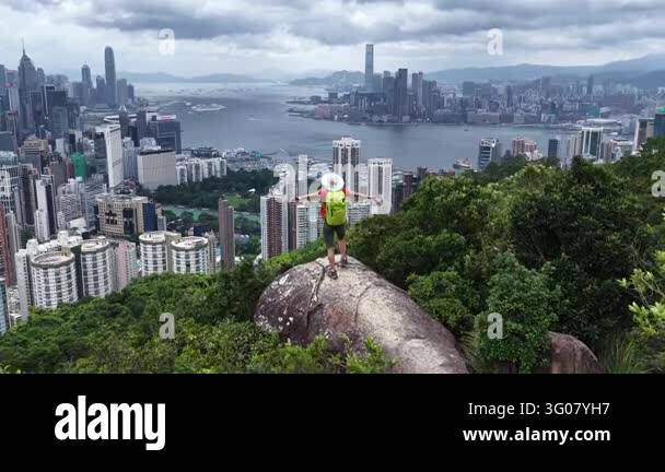 Aerial view of a person standing on a rock with arms outstretched ...