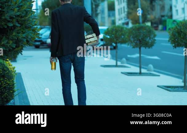 Professional Fails Highly stressed adult worker walks outdoors holding a cold beer bottle ...
