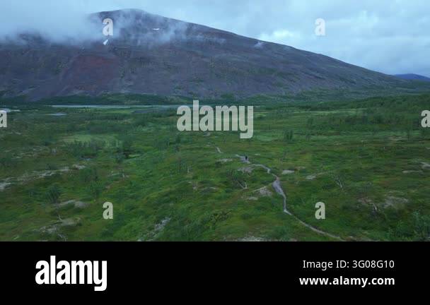 Aerial push in drone shot showing the Kaitumjaure camp along the ...