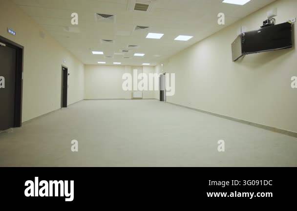 News Panel Empty Long empty hall features cream walls dark entrance doors wall mounted ...
