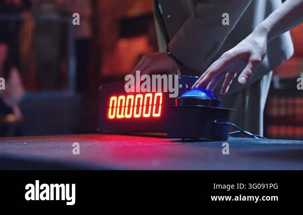 Person presses large blue dome button next to digital LED timer. Tense ...