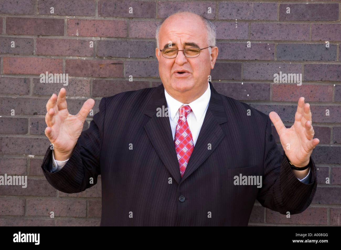 Mature businessman in suit with expansive gesture. Stock Photo