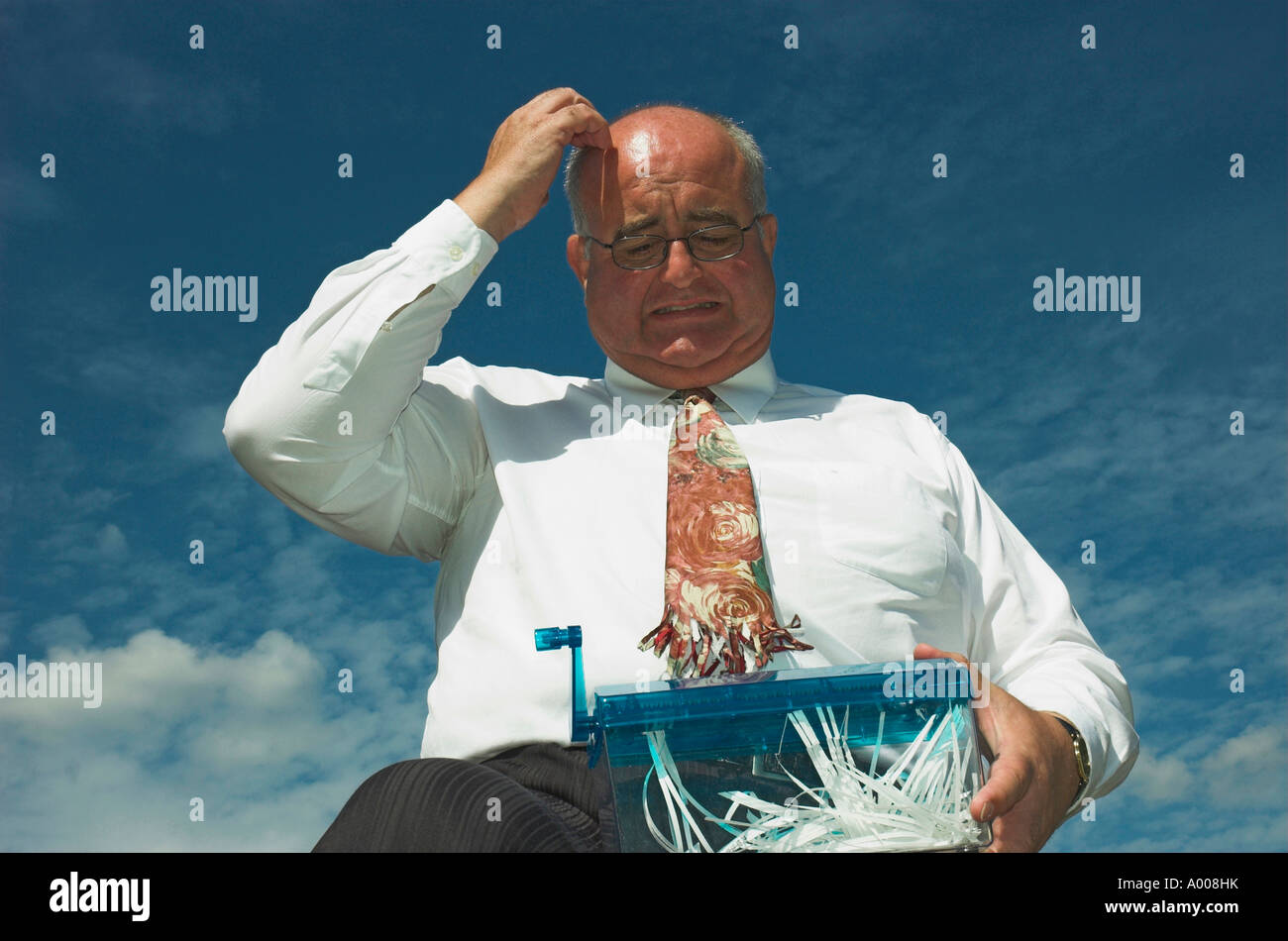 Mature businessman has an accident with the paper shredder! Stock Photo