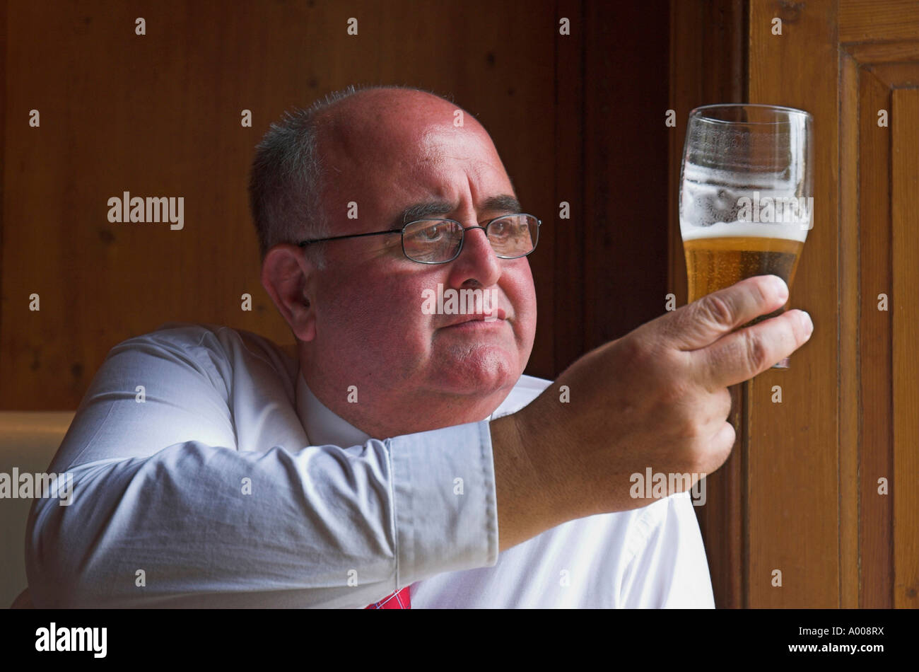 Mature man enjoying a lunchtime pint in the pub Stock Photo