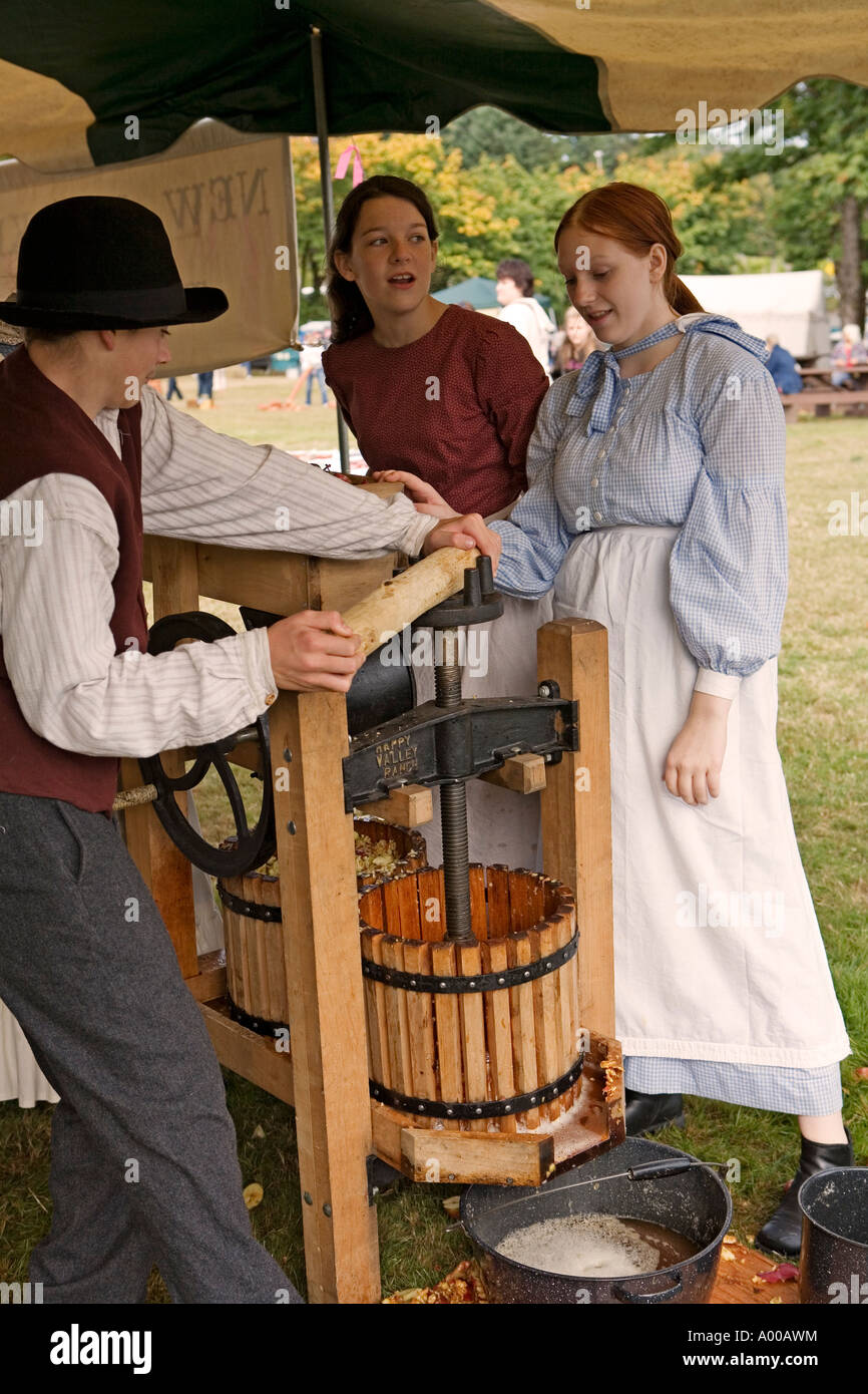 Image of a group of teenagers dressed in pioneer clothing making apple  cider using an apple press Stock Photo - Alamy