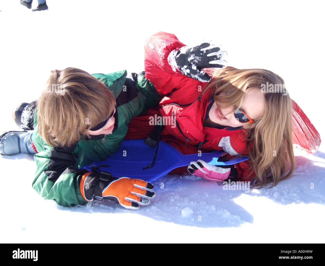 2 two happy smiling laughing children playing in snow boy and girl Stock Photo