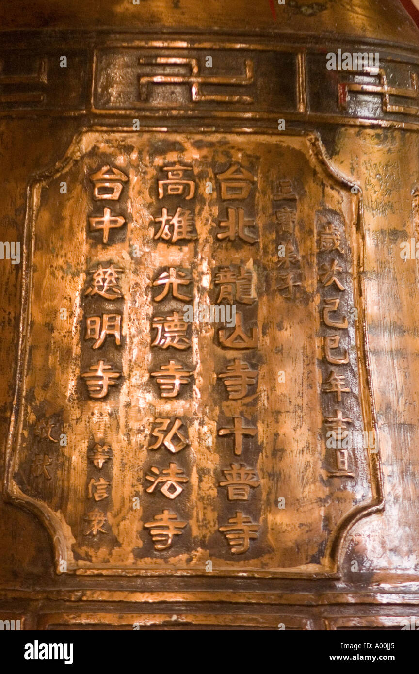 Close up of golden Chinese buddhist bell with script and swasticas at Chinese Chan monastery in Bodhgaya, Bihar, India. Stock Photo