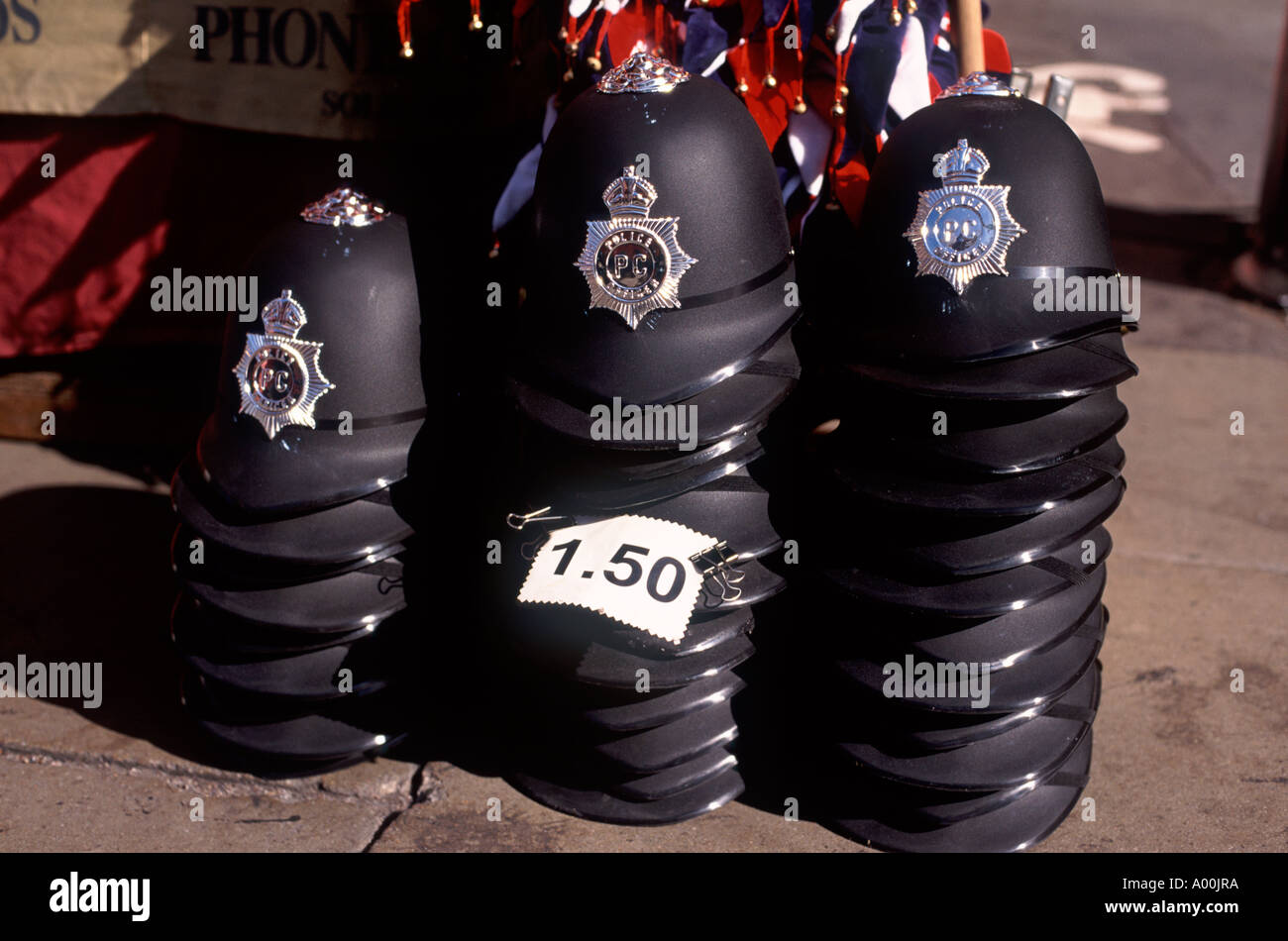 Plastic bobby helmets piled for sale at outdoor market stall on Oxford Street, London, England Stock Photo