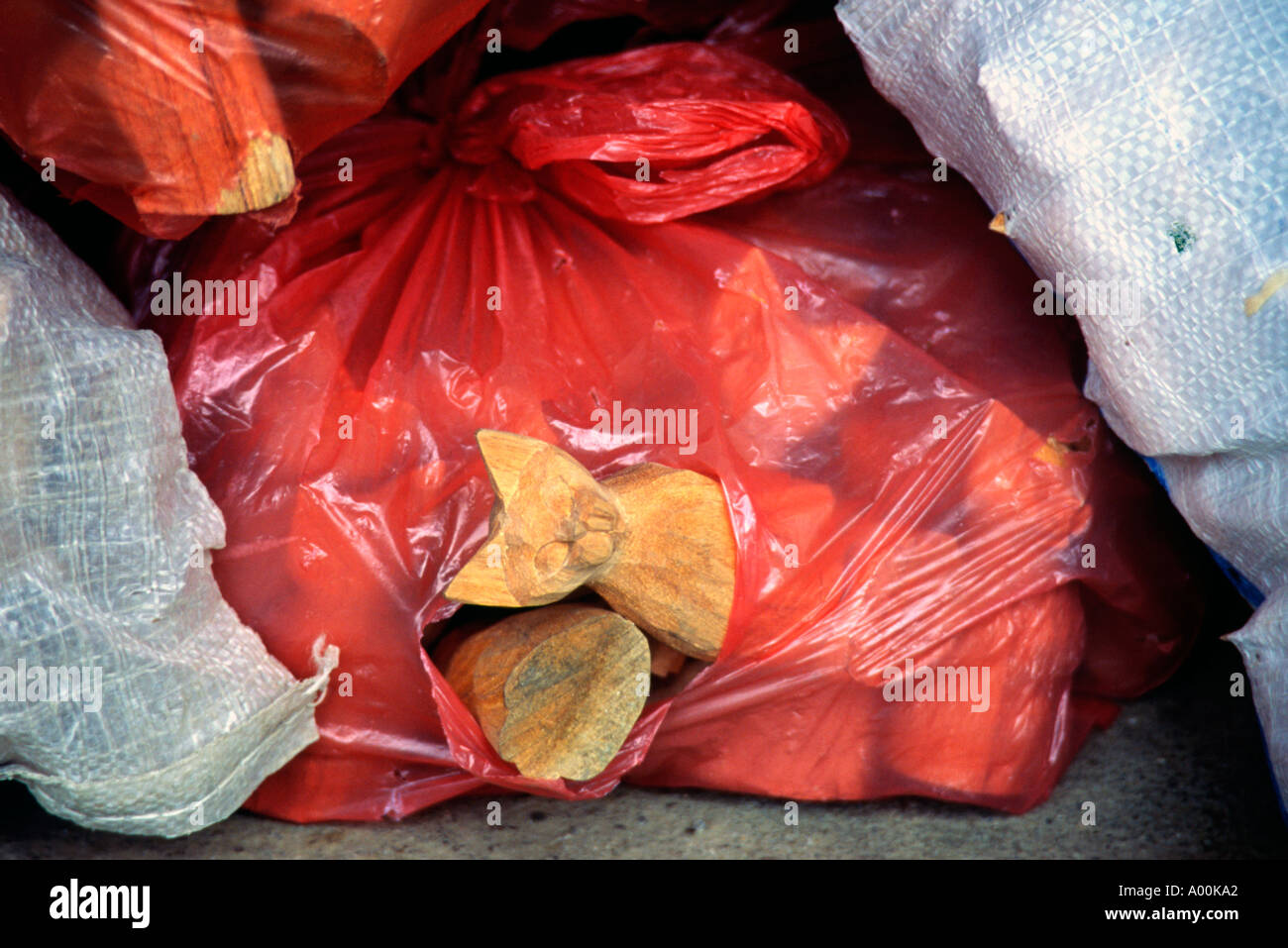 small carving of a cat pokes out of split in a large bag of carved cats outside of a workshop in the tegalallang near ubud bali Stock Photo