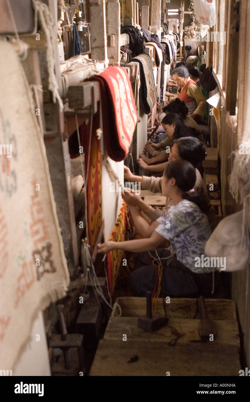 Row of women weaving carpets in Tibetan Refugee Help Centre in Darjeeling West Bengal India Stock Photo