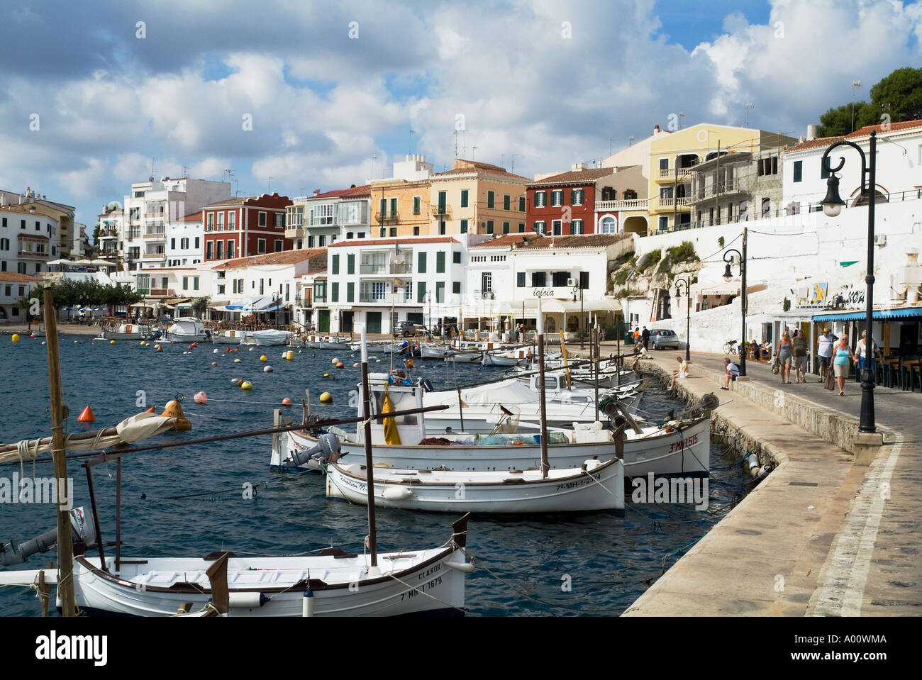 dh Cales Fonts ES CASTELL MENORCA Fishing boat anchored at quayside people minorca harbour fishboats buildings Stock Photo