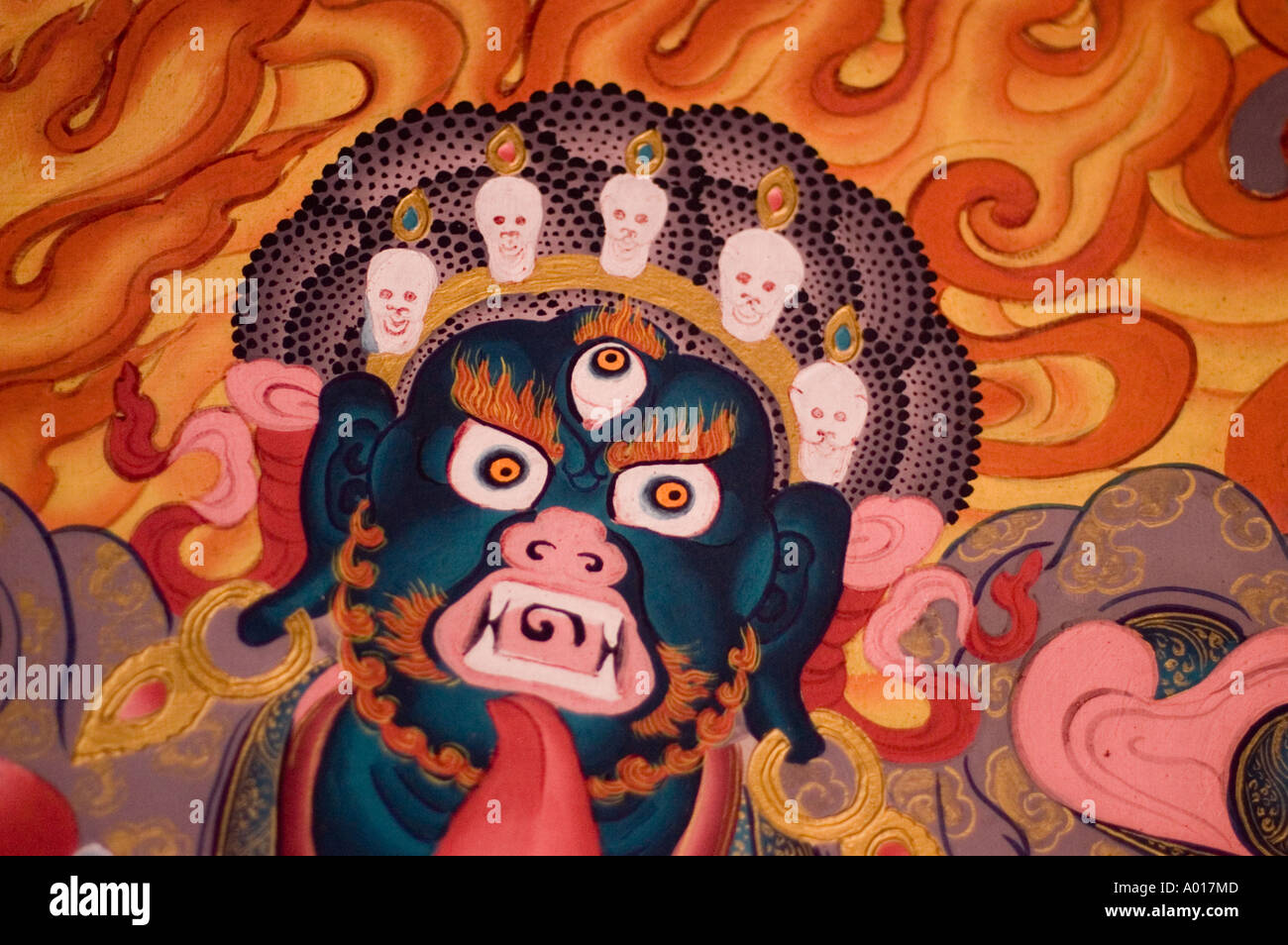 Close up mural painting of a wrathful deity face at Namchi Nyingma monastery, Sikkim, India. Features blue skin, three eyes, and a skull crown. Stock Photo