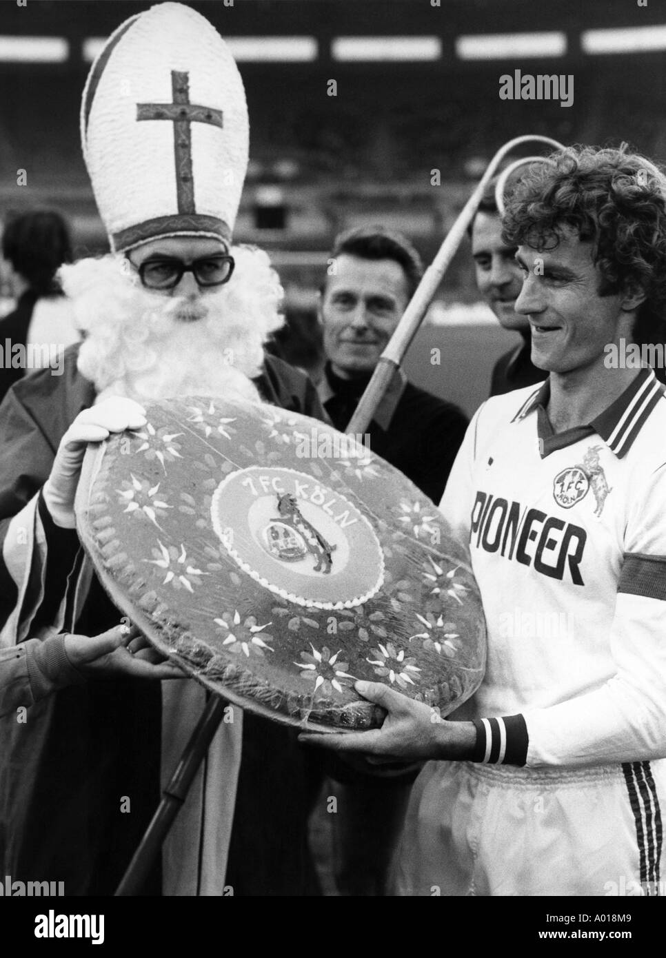 football, Bundesliga, 1980/1981, Fortuna Duesseldorf versus 1. FC Cologne 0:0, Rhine Stadium, St Nicholas gives a large gingerbread as a present to the Cologne captain Reiner Bonhof, b&w, black and white, black & white photography Stock Photo