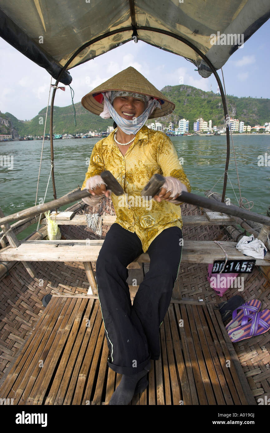 Conical hat woman rows tourists around 