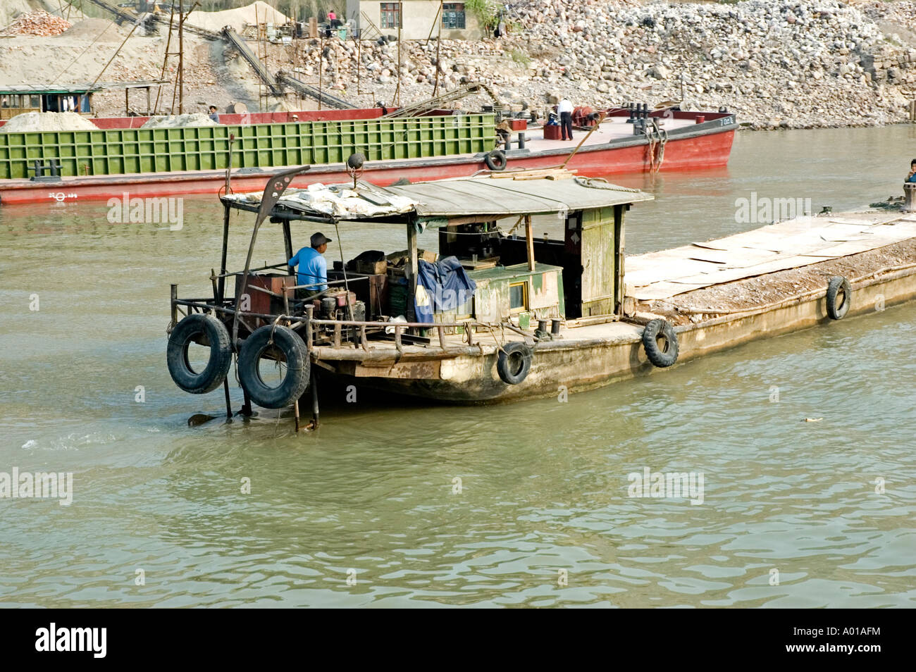 Chinese workers loading broken rock onto barges on the banks of the Yangtze river, Nanjing, China Stock Photo