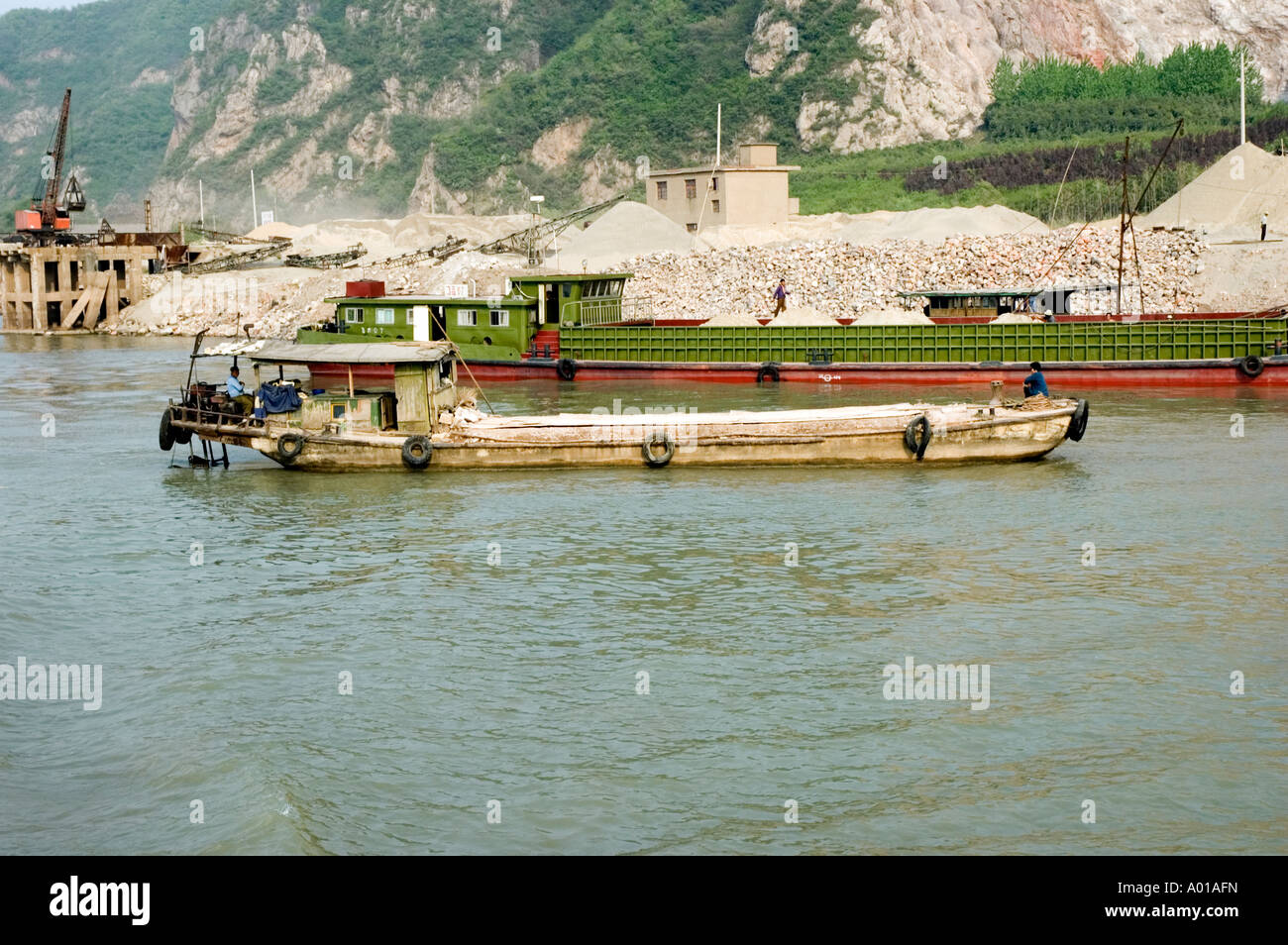 Chinese workers loading broken rock onto barges on the banks of the Yangtze river, Nanjing Stock Photo