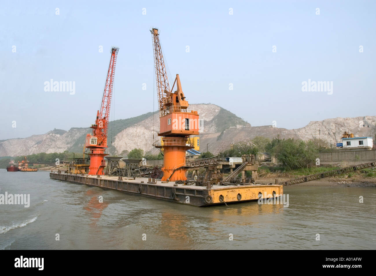 A floating dock carrying two large orange cranes on the Yangtze River, Nanjing, China Stock Photo